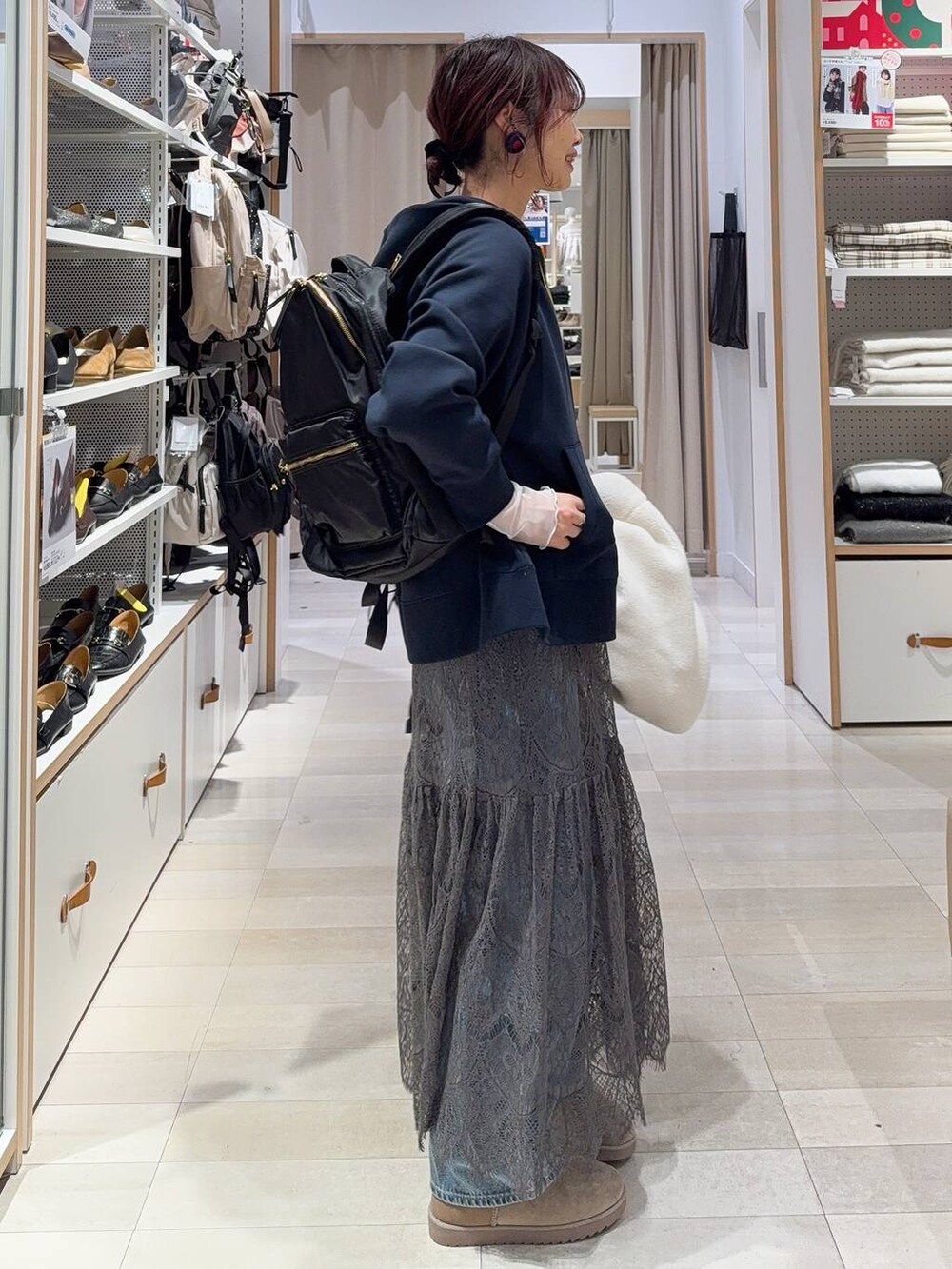 ホワイト系のブルゾン、ブルー系のデニムパンツ、ブラック系のバックパック/リュックを着用したレディースの冬コーディネートの8枚目の写真