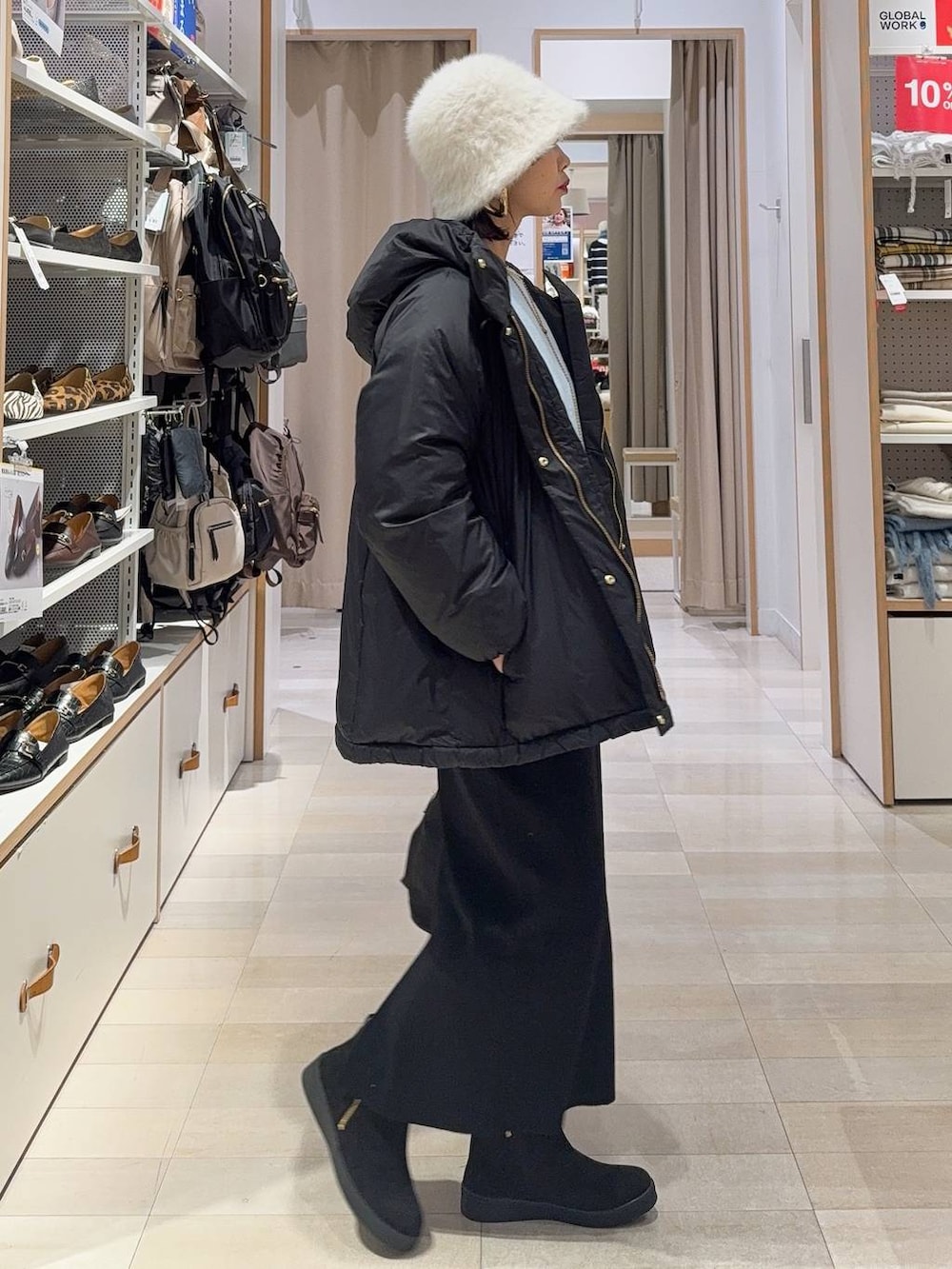 ブラック系のショルダーバッグ、ブラック系のダウンジャケット/コート、ブルー系のニット/セーターを着用したレディースの冬コーディネートの4枚目の写真