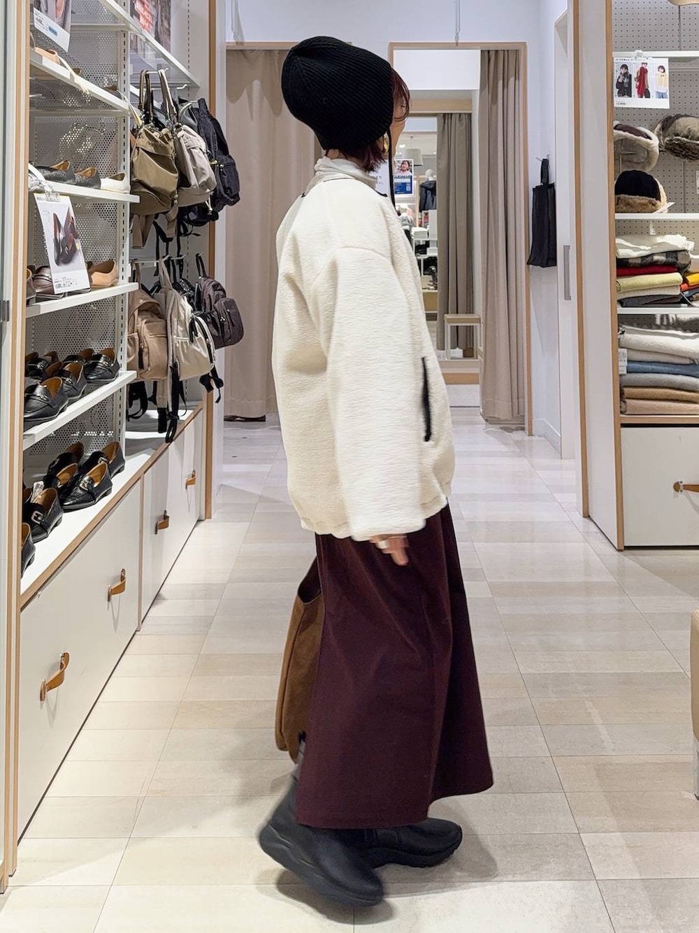 ホワイト系のブルゾン、レッド系のスカート、ベージュ系のトートバッグを着用したレディースの秋コーディネートの4枚目の写真