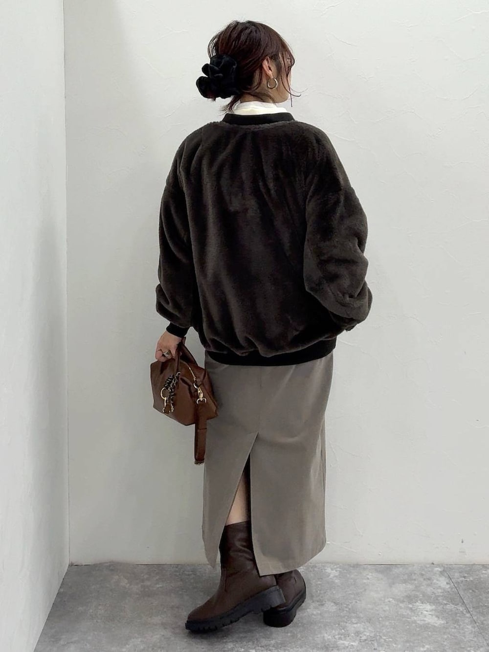 ブラック系のブルゾン、ブラウン系のスカート、ブラウン系のブーツを着用したレディースの冬コーディネートの6枚目の写真