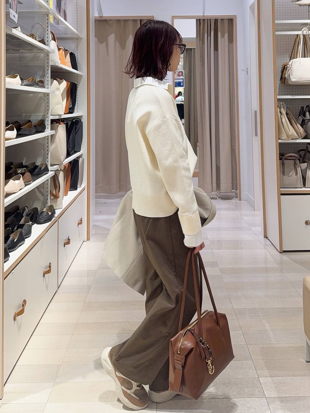 ブラウン系のボストンバッグ、ブラウン系のその他パンツ、ブラウン系のその他シューズを着用したレディースの冬コーディネートの6枚目の写真