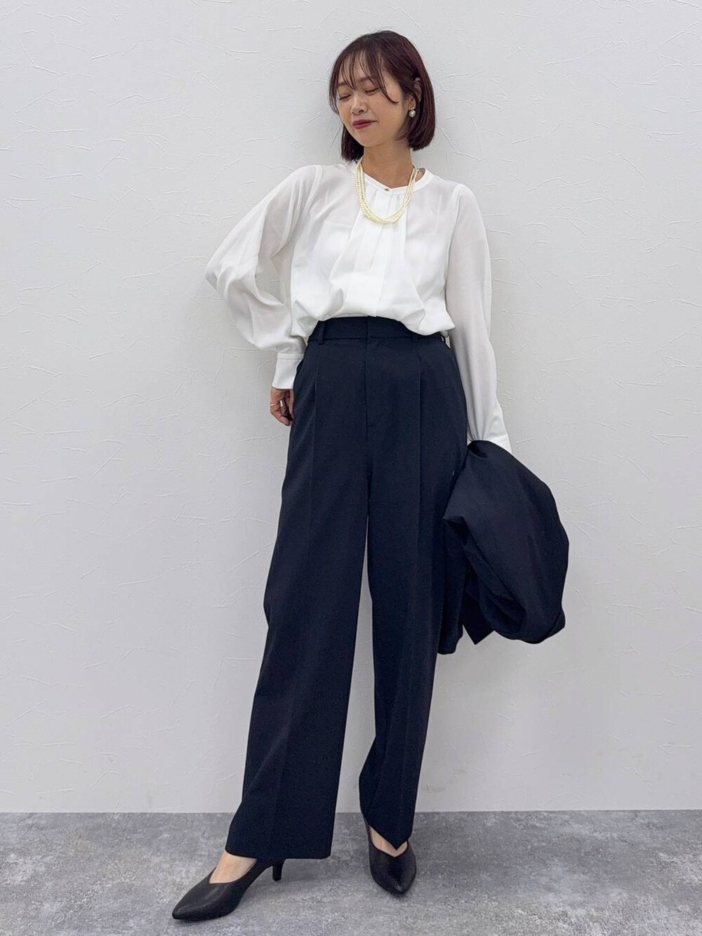 ブラック系のショルダーバッグ、ブルー系のスラックス、ホワイト系のシャツ/ブラウスを着用したレディースの秋コーディネートの2枚目の写真