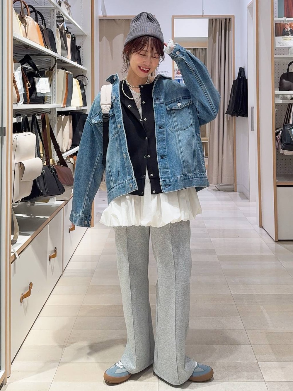 ブルー系のスニーカー、ホワイト系のバックパック/リュック、ホワイト系のTシャツ/カットソーを着用したレディースの冬コーディネートの2枚目の写真