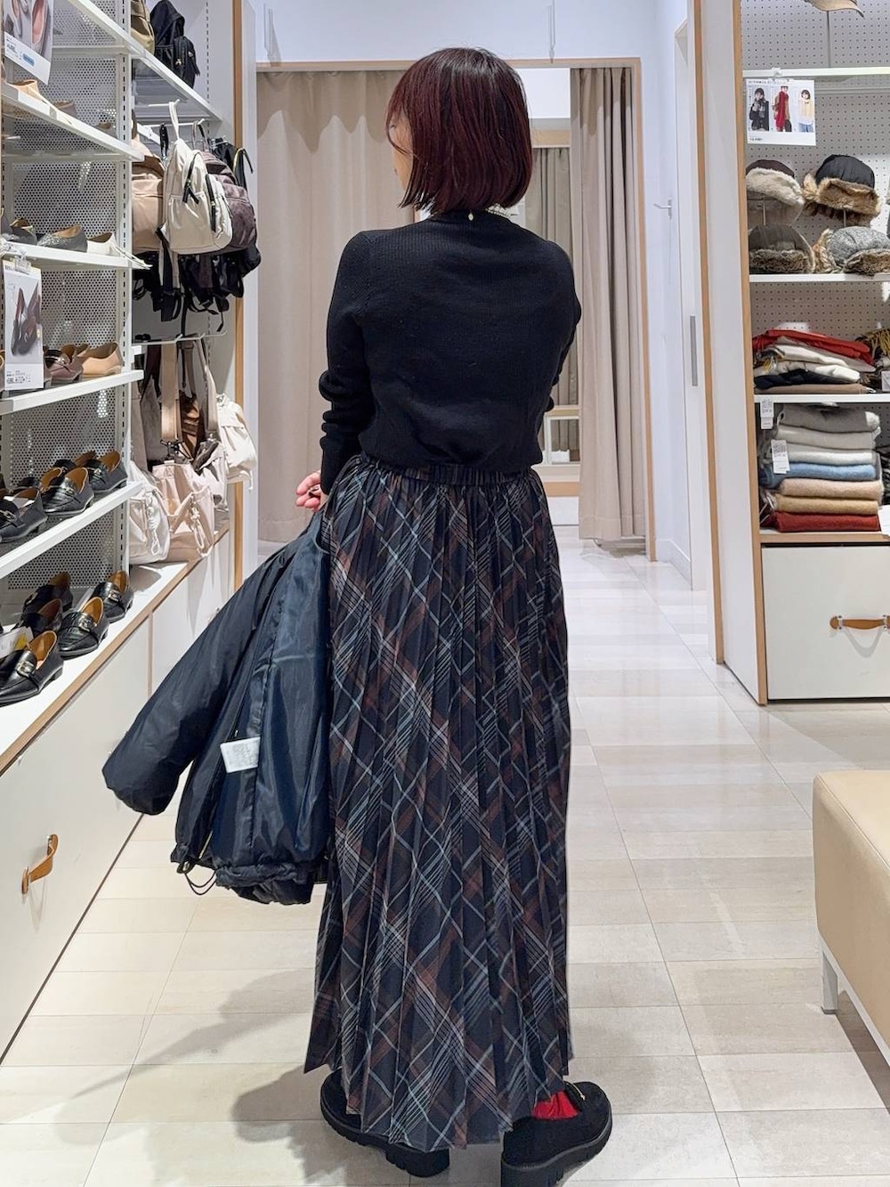 ブルー系のダウンジャケット/コート、ブラウン系のボストンバッグ、ブラック系のニット/セーターを着用したレディースの冬コーディネートの6枚目の写真