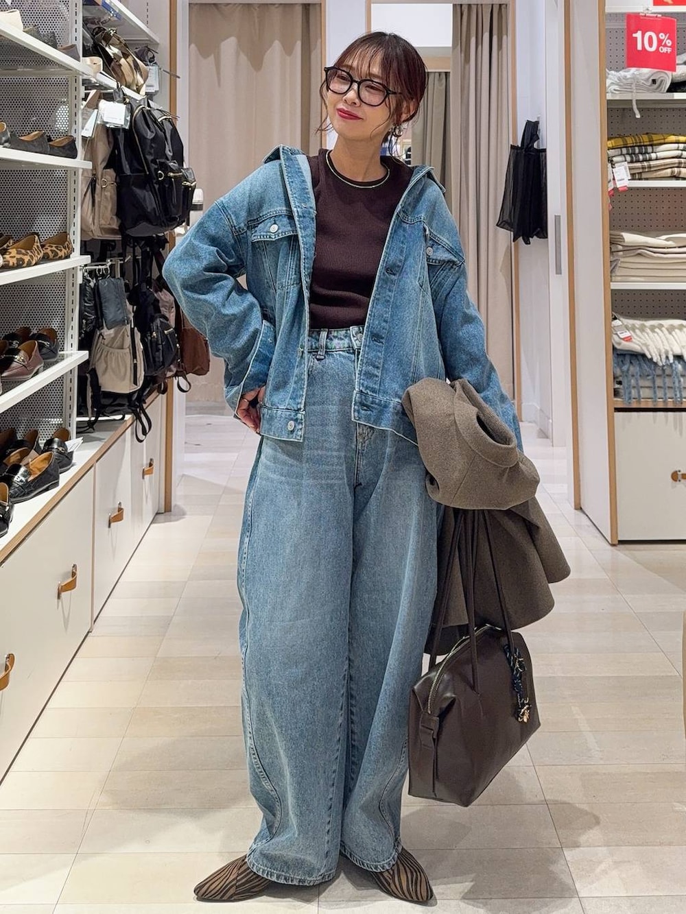 グリーン系のスニーカー、ブルー系のデニムジャケット、ブラック系のスカートを着用したレディースの冬コーディネートの3枚目の写真