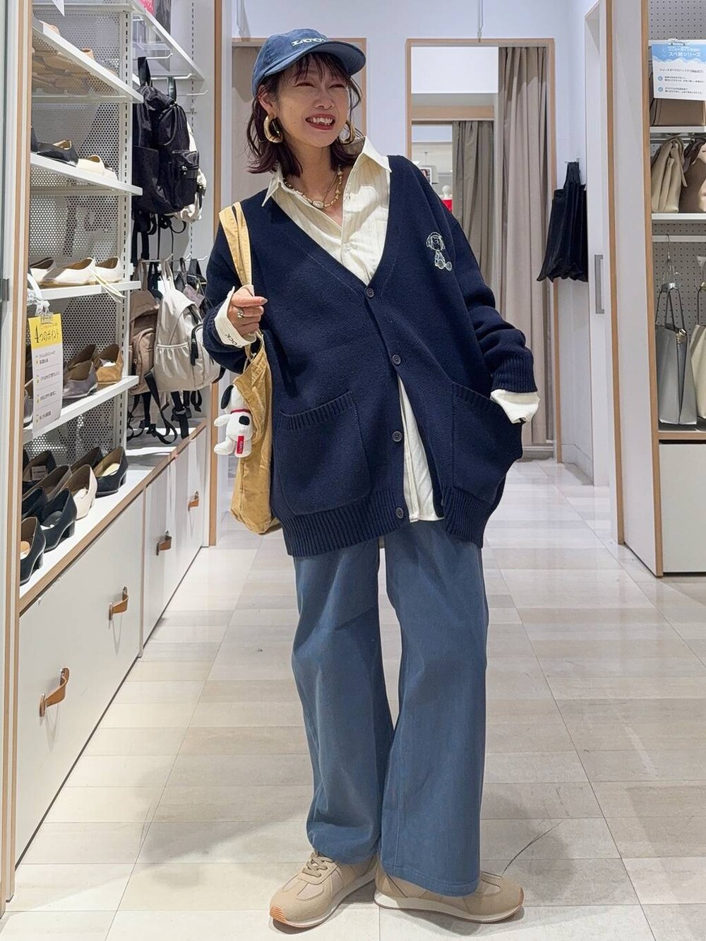 ベージュ系のスニーカー、ブルー系のカーディガン/ボレロ、ゴールド系のシャツ/ブラウスを着用したレディースの秋コーディネートの2枚目の写真