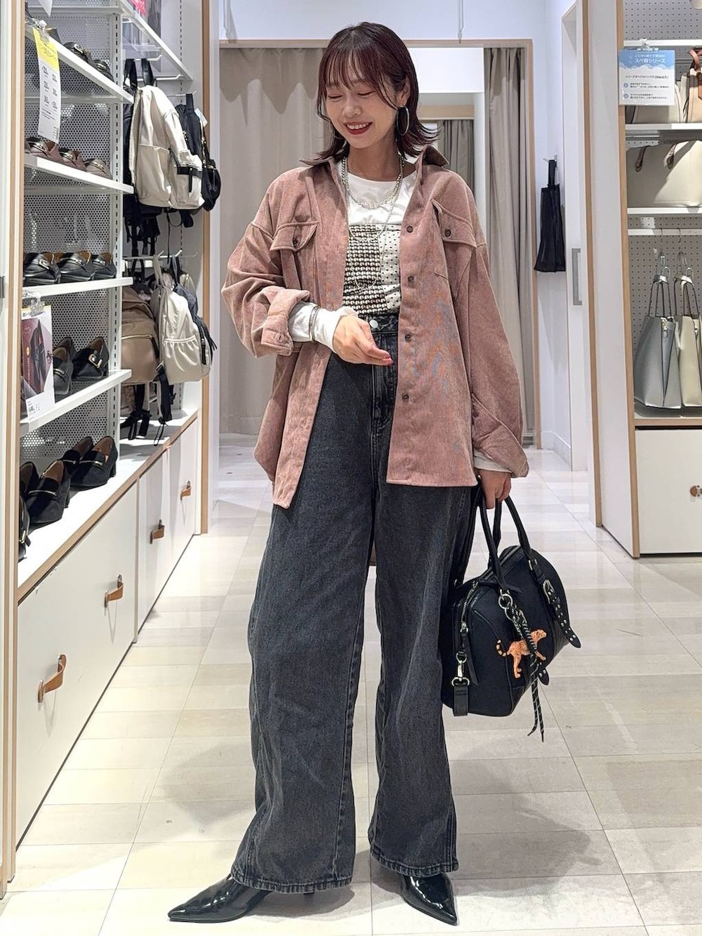 ピンク系のシャツ/ブラウス、ブラック系のボストンバッグ、ブラウン系のベストを着用したレディースの秋コーディネートの3枚目の写真