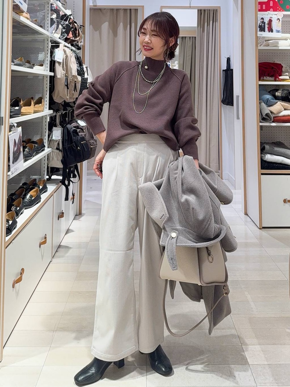 ベージュ系のチェスターコート、グレー系のその他パンツ、ベージュ系のトートバッグを着用したレディースの冬コーディネートの2枚目の写真