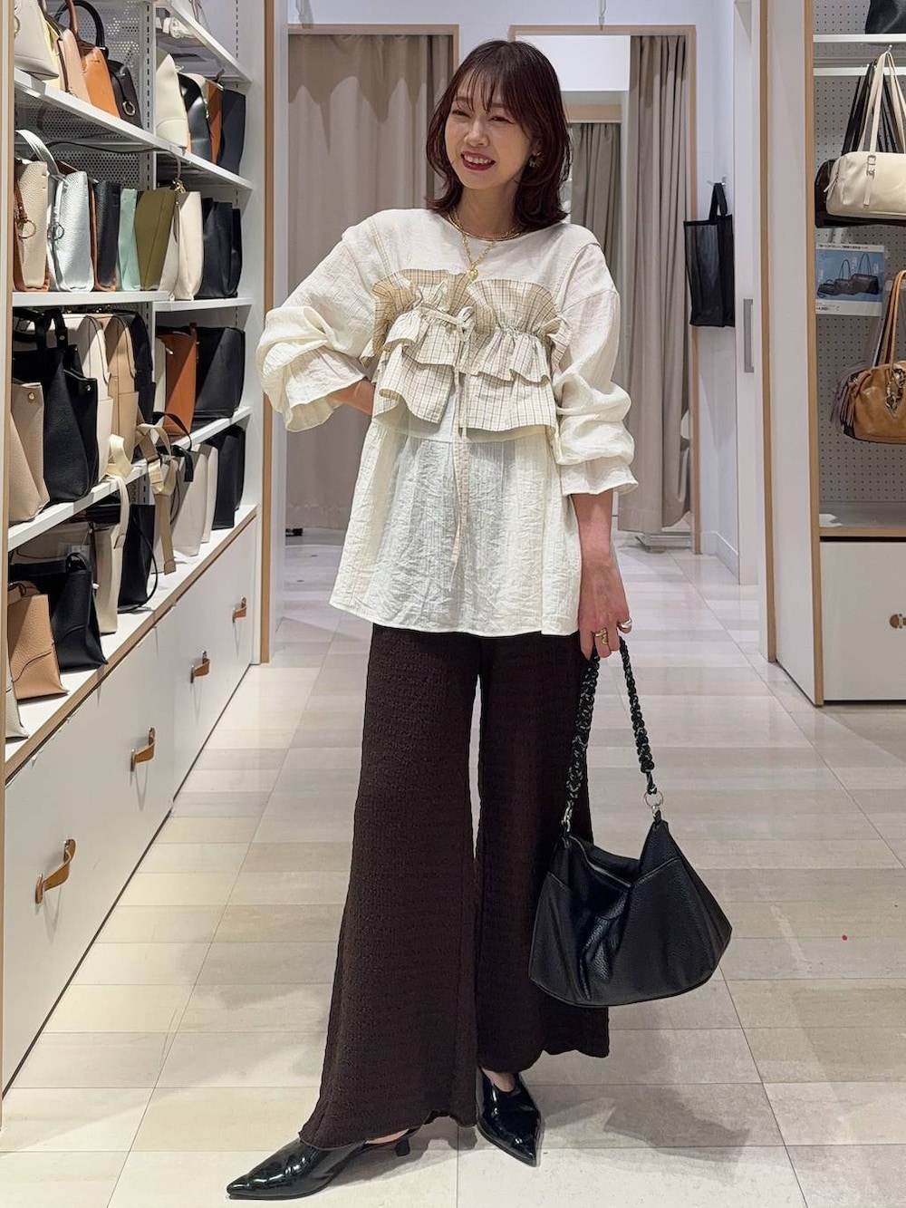 ホワイト系のブルゾン、ブラウン系のキャミソール、ブラウン系のその他パンツを着用したレディースの春コーディネートの4枚目の写真