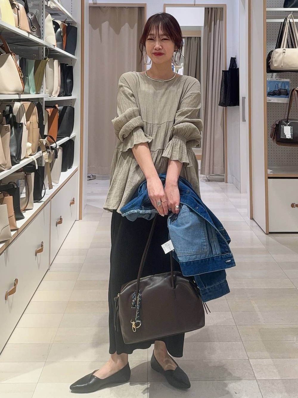 ホワイト系のブルゾン、ブラック系のショルダーバッグ、グレー系のスカートを着用したレディースの春コーディネートの7枚目の写真