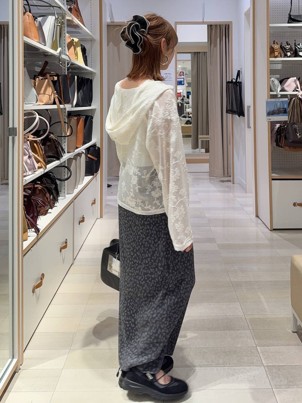 ベージュ系のパーカー、ホワイト系のタンクトップ、ブラック系のトートバッグを着用したレディースの春コーディネートの3枚目の写真