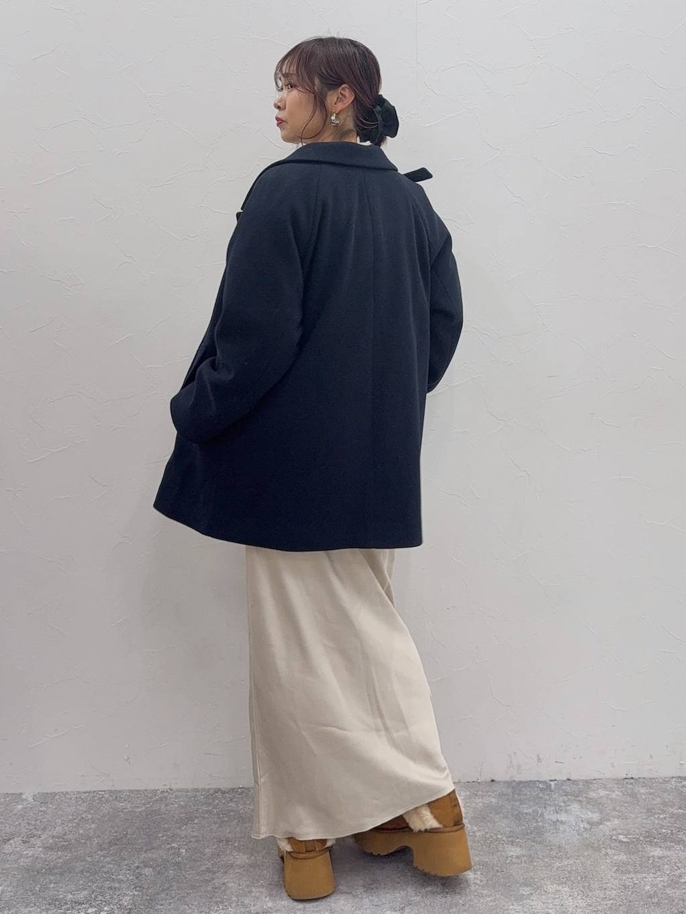 ホワイト系のスカート、ブルー系のチェスターコート、イエロー系のブーツを着用したレディースの冬コーディネートの4枚目の写真