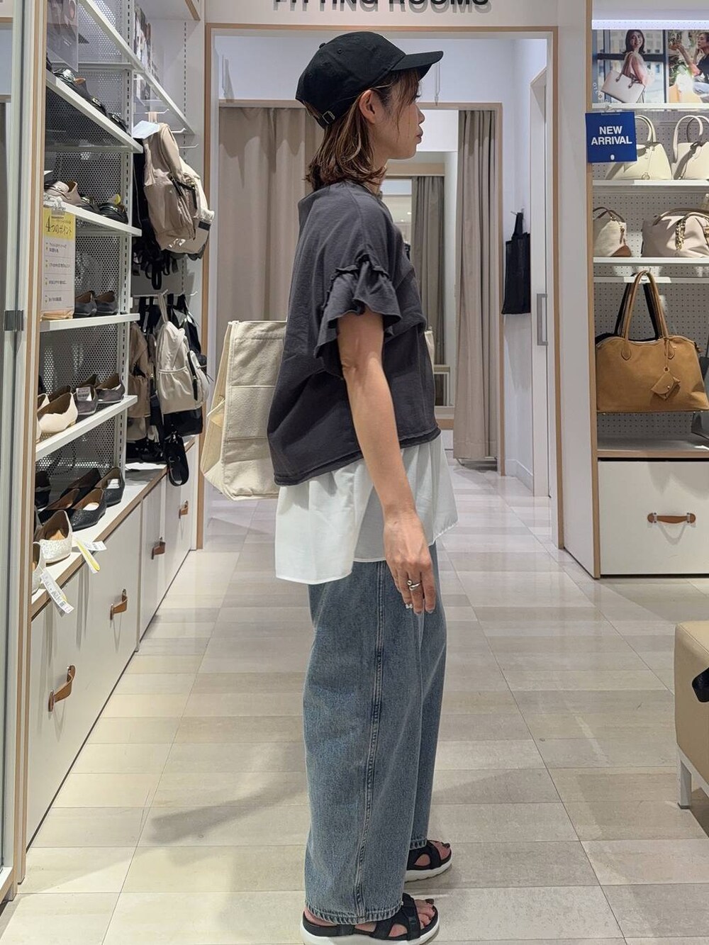 ブラック系のサンダル、ブラック系のTシャツ/カットソー、ブルー系のデニムパンツを着用したレディースの夏コーディネートの3枚目の写真