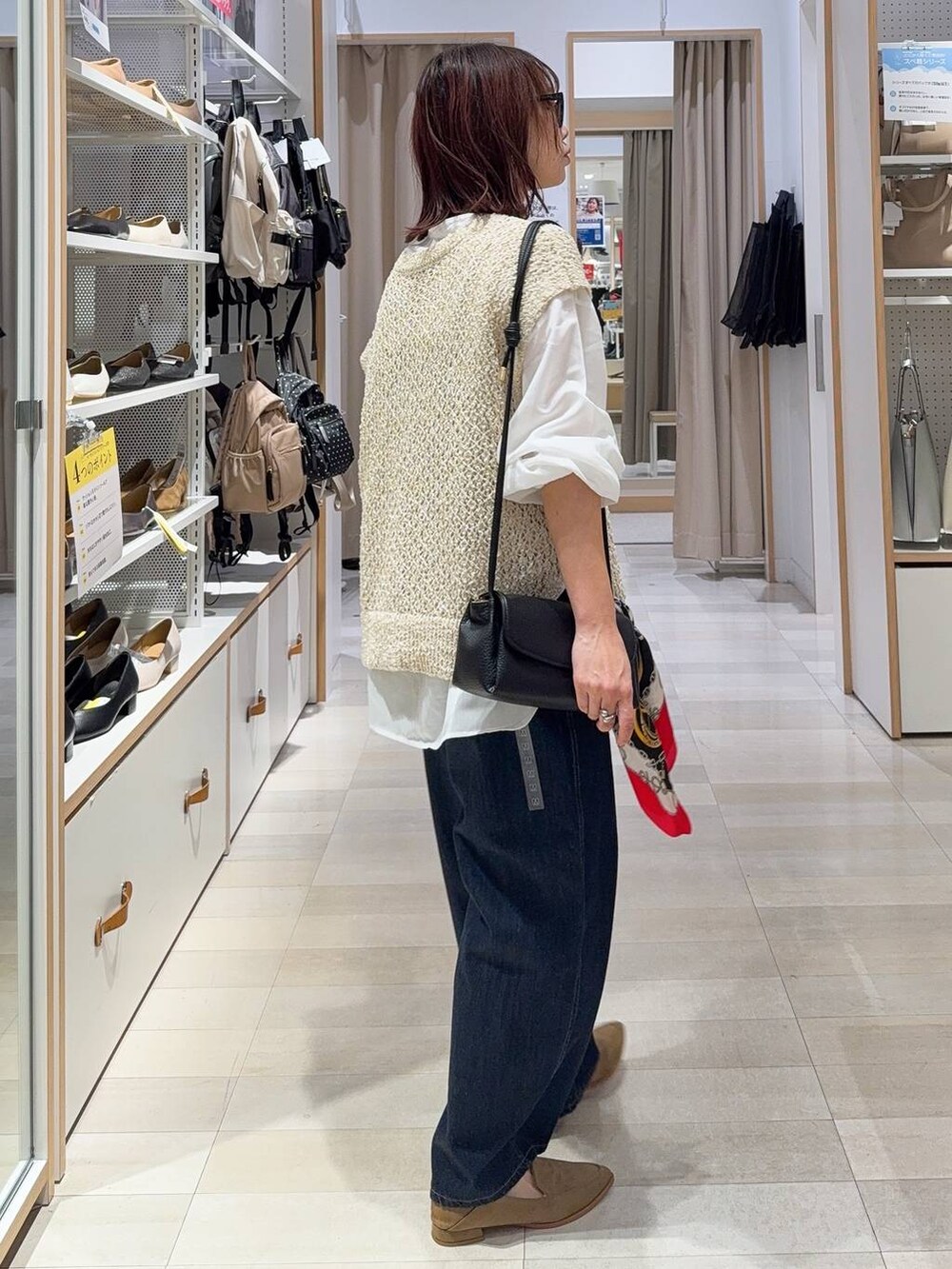 ブルー系のデニムパンツ、ベージュ系のシャツ/ブラウス、ブラック系のショルダーバッグを着用したレディースの秋コーディネートの2枚目の写真