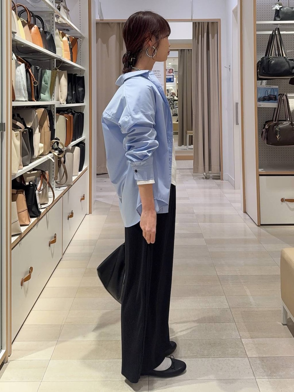 ブラック系のバレエシューズ、ブルー系のシャツ/ブラウス、ブラック系のスカートを着用したレディースの春コーディネートの6枚目の写真