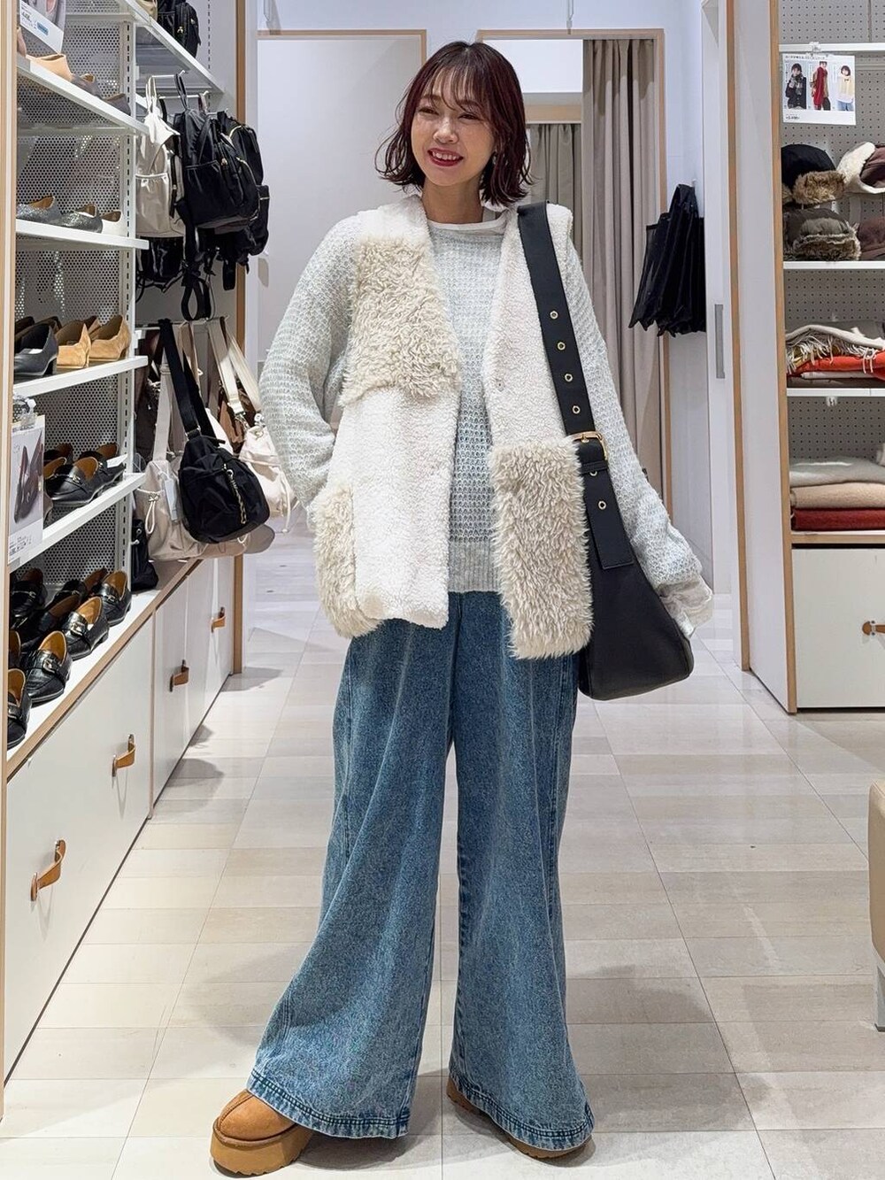 ブラック系のショルダーバッグ、グレー系のニット/セーター、イエロー系のブーツを着用したレディースの冬コーディネートの3枚目の写真