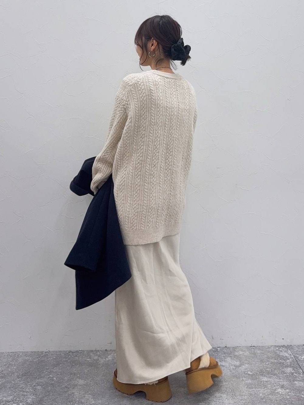 ホワイト系のスカート、ブルー系のチェスターコート、イエロー系のブーツを着用したレディースの冬コーディネートの6枚目の写真