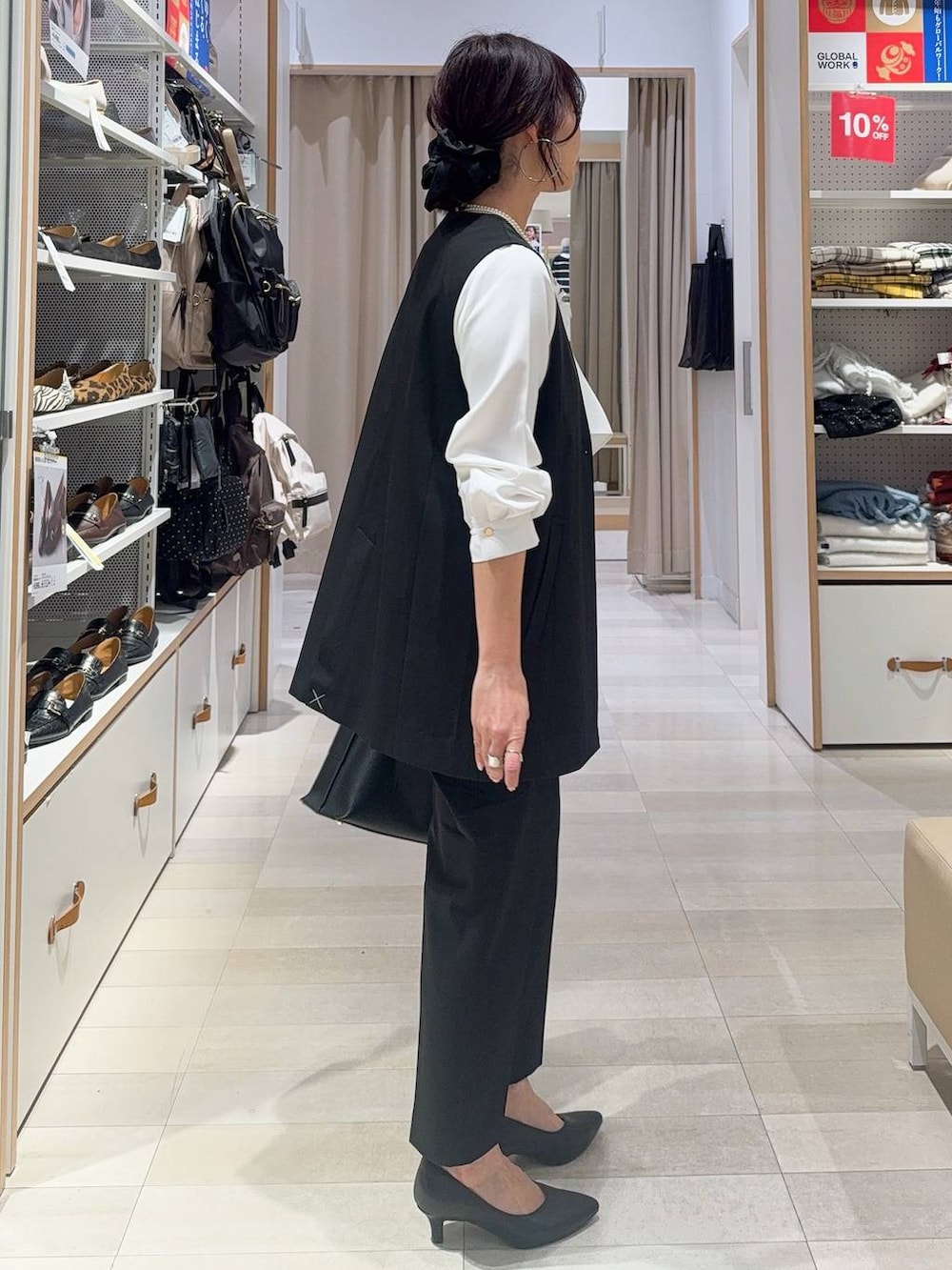 ブラック系のパンプス、ブラック系のスラックス、ホワイト系のシャツ/ブラウスを着用したレディースの冬コーディネートの6枚目の写真