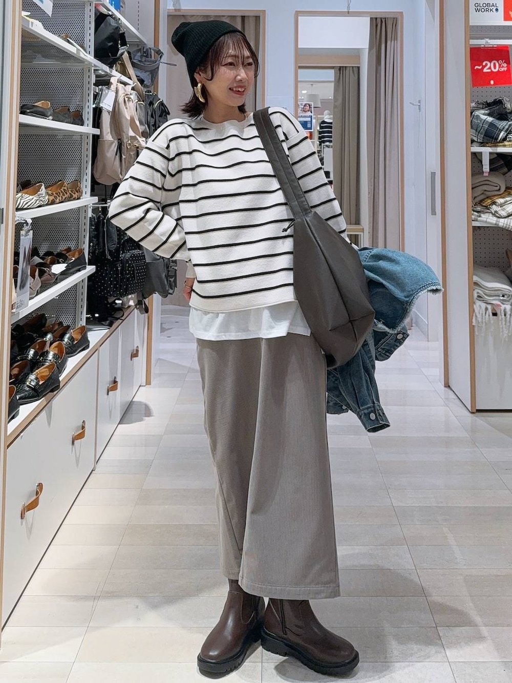 ブラウン系のショルダーバッグ、ブラウン系のスカート、ホワイト系のTシャツ/カットソーを着用したレディースの冬コーディネートの2枚目の写真