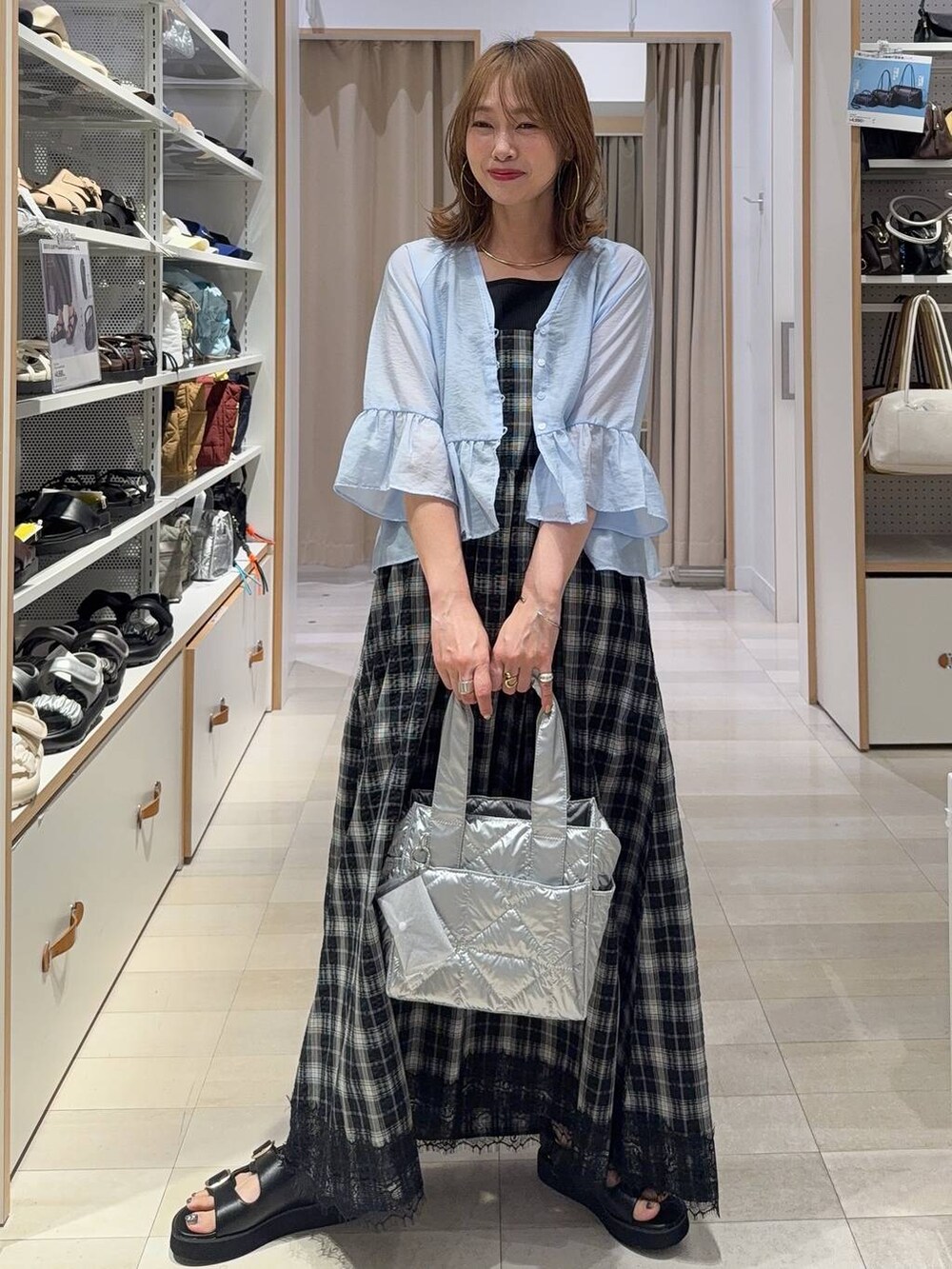 ホワイト系のトートバッグ、ブルー系のデニムパンツ、ホワイト系のサンダルを着用したレディースの春コーディネートの2枚目の写真