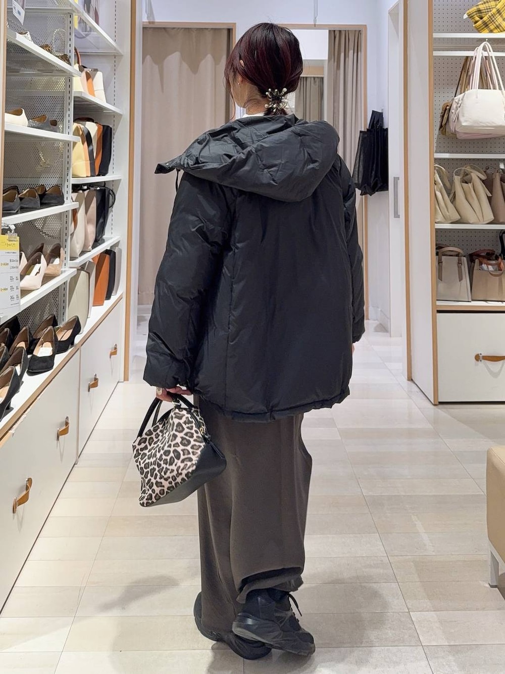 その他のショルダーバッグ、ブラック系のダウンジャケット/コート、ホワイト系のニット/セーターを着用したレディースの冬コーディネートの4枚目の写真