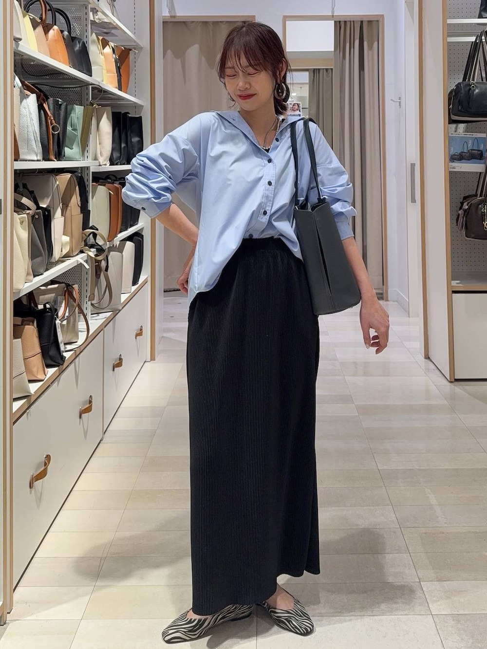 ブラック系のバレエシューズ、ブルー系のシャツ/ブラウス、ブラック系のスカートを着用したレディースの春コーディネートの3枚目の写真