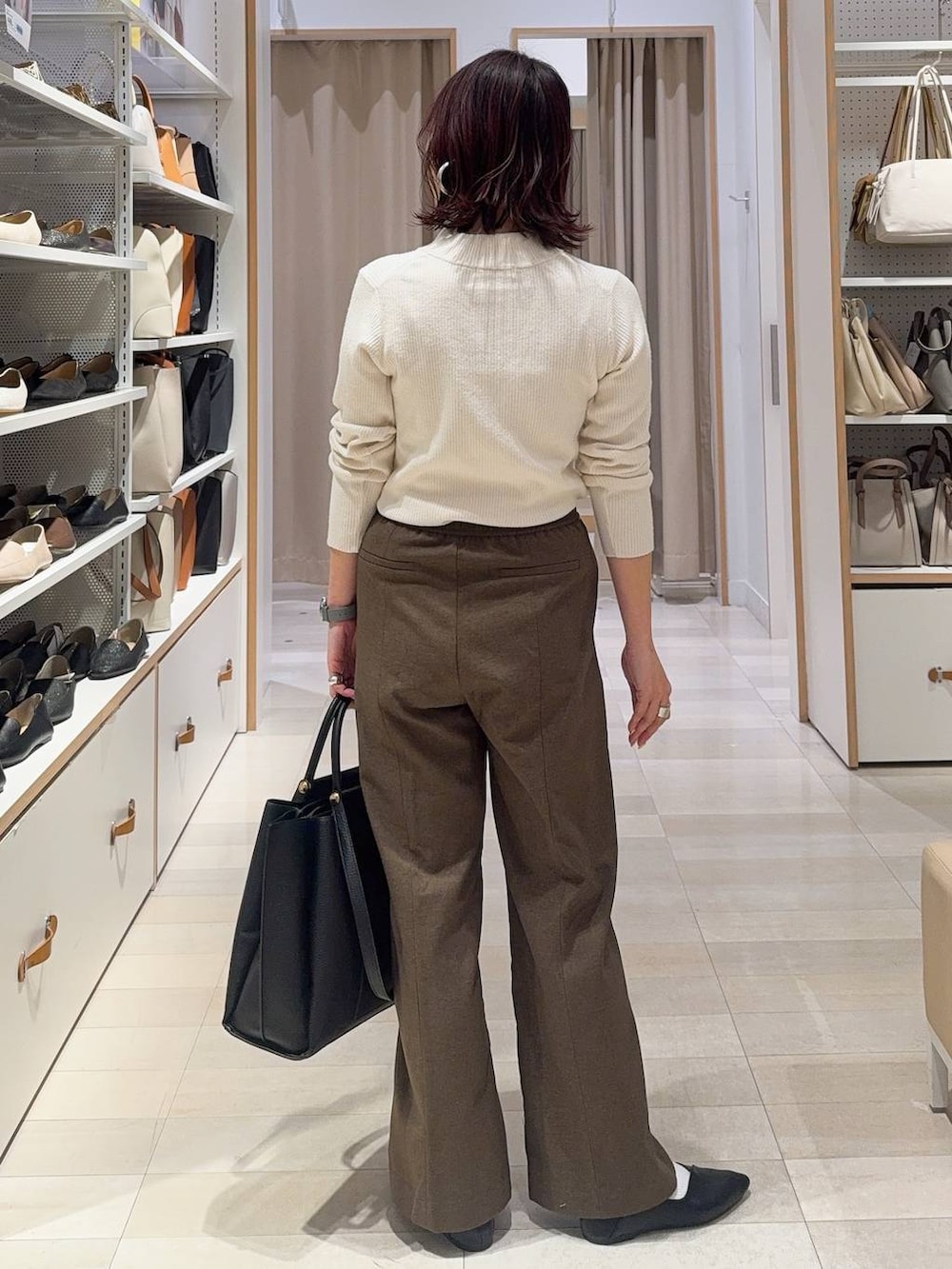 ブラック系のパンプス、ホワイト系のニット/セーター、ブラウン系のその他パンツを着用したレディースの冬コーディネートの8枚目の写真