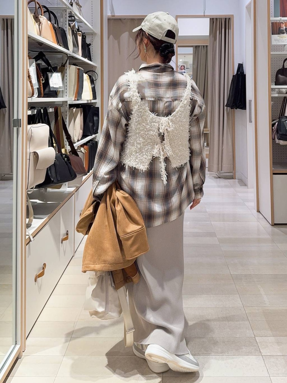 ホワイト系のショルダーバッグ、ホワイト系のスニーカー、ブラウン系のテーラードジャケットを着用したレディースの冬コーディネートの7枚目の写真