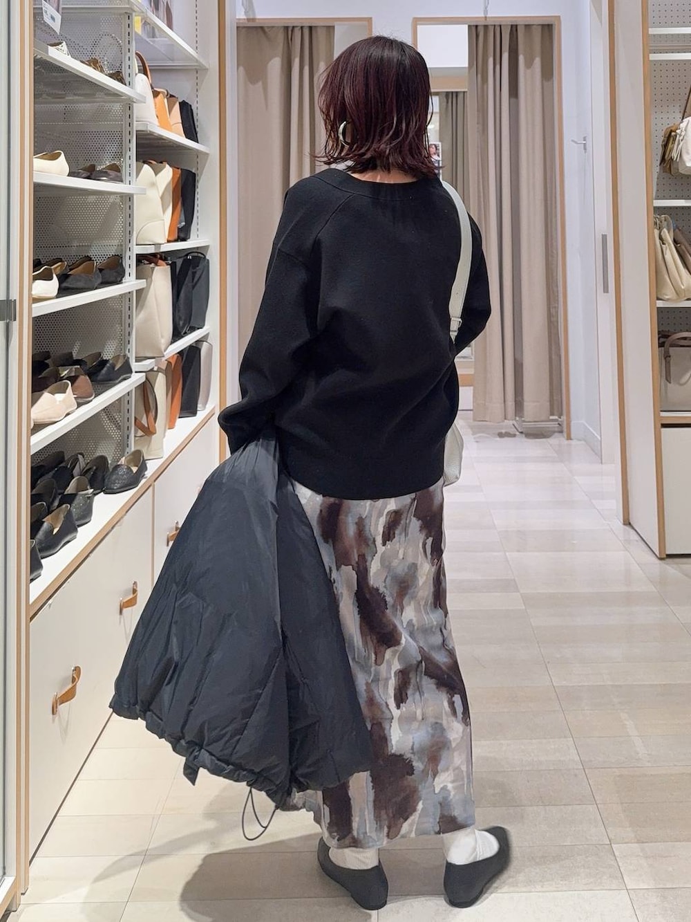 ブラック系のパンプス、ホワイト系のキャミソール、ブルー系のダウンジャケット/コートを着用したレディースの冬コーディネートの7枚目の写真