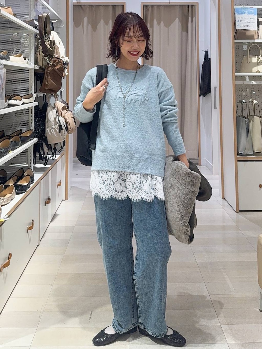 ブラック系のバレエシューズ、グレー系のブルゾン、ブルー系のデニムパンツを着用したレディースの秋コーディネートの3枚目の写真