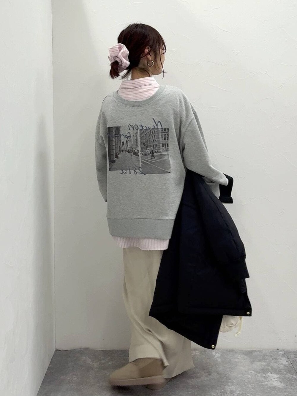 ホワイト系のショルダーバッグ、ブラック系のダウンジャケット/コート、ホワイト系のスカートを着用したレディースの冬コーディネートの7枚目の写真