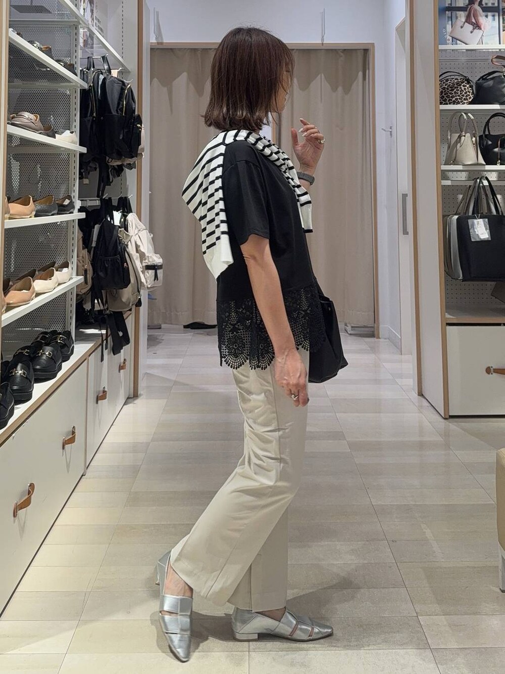 ブラック系のショルダーバッグ、ブルー系のカーディガン/ボレロ、グレー系のパンプスを着用したレディースの夏コーディネートの3枚目の写真