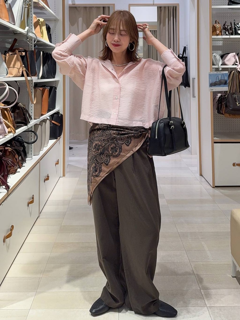 グレー系のスニーカー、ブラック系のバックパック/リュック、ピンク系のシャツ/ブラウスを着用したレディースの春コーディネートの2枚目の写真