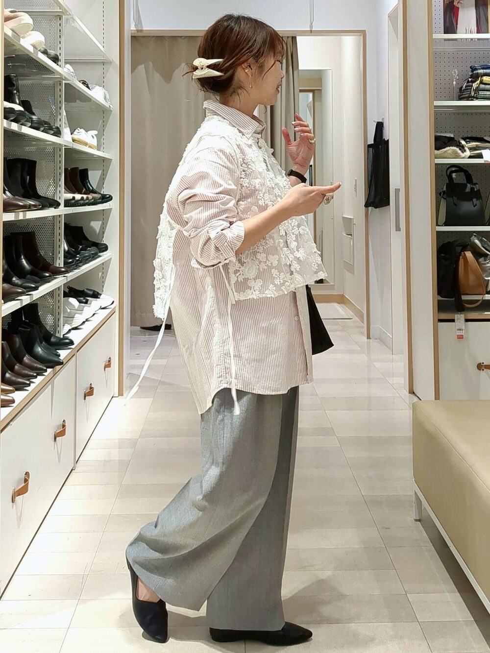 ブラック系のスニーカー、ホワイト系のショルダーバッグ、ピンク系のシャツ/ブラウスを着用したレディースの春コーディネートの5枚目の写真