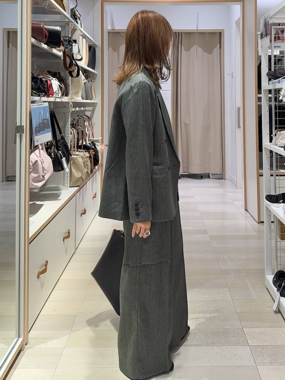 グレー系のその他パンツ、ブラック系のブーツ、ブラック系のトートバッグを着用したレディースの秋コーディネートの4枚目の写真