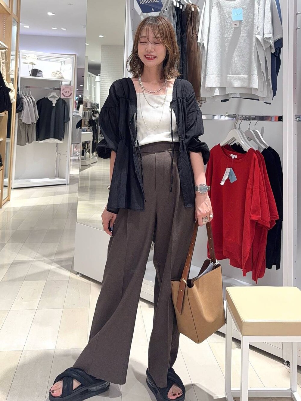 ブルー系のデニムパンツ、ブラック系のボストンバッグ、ブラック系のシャツ/ブラウスを着用したレディースの秋コーディネートの4枚目の写真