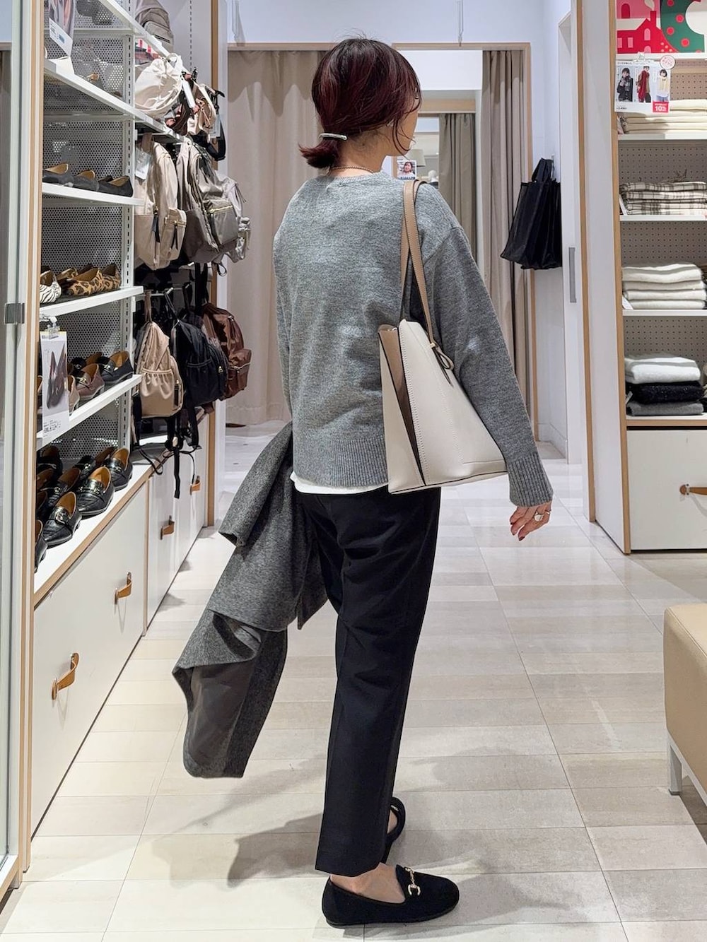 グレー系のチェスターコート、ブラック系のその他パンツ、ホワイト系のTシャツ/カットソーを着用したレディースの冬コーディネートの8枚目の写真