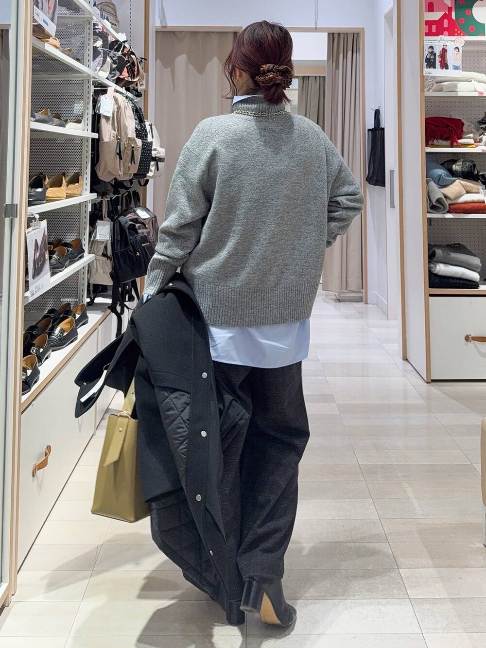 グリーン系のショルダーバッグ、ブラック系のステンカラーコート、ブルー系のシャツ/ブラウスを着用したレディースの冬コーディネートの6枚目の写真