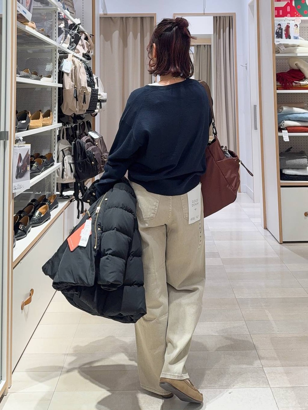 ブラック系のダウンジャケット/コート、ベージュ系のデニムパンツ、ホワイト系のTシャツ/カットソーを着用したレディースの冬コーディネートの7枚目の写真