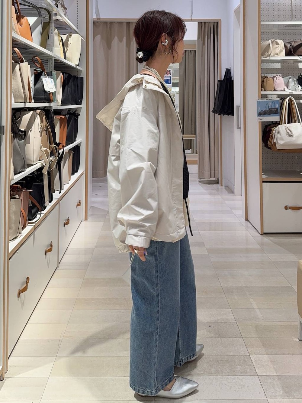 ホワイト系のパンプス、ブルー系のデニムパンツ、ベージュ系のマウンテンパーカーを着用したレディースの春コーディネートの3枚目の写真