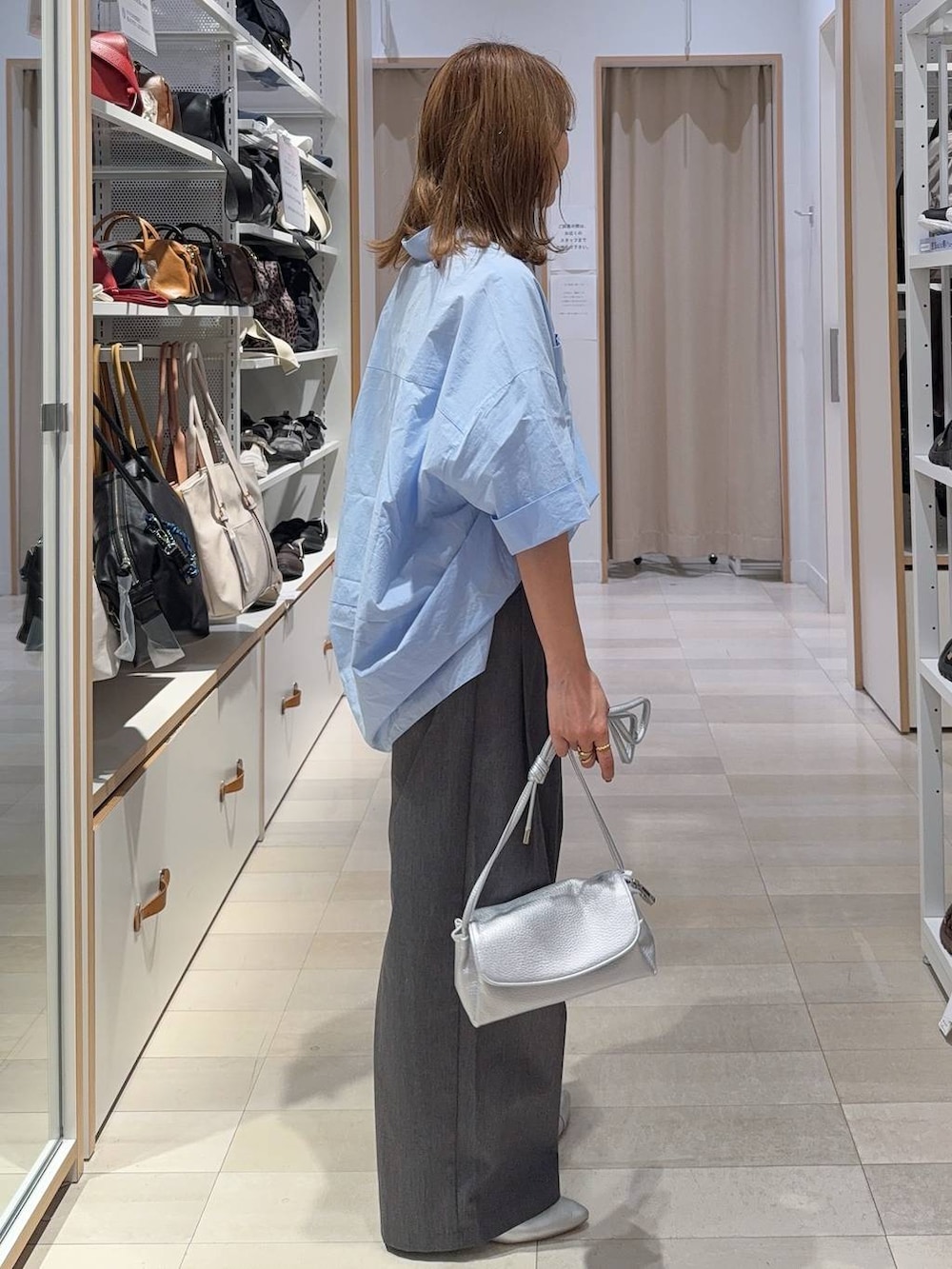 シルバー系のパンプス、シルバー系のショルダーバッグ、ブルー系のシャツ/ブラウスを着用したレディースの夏コーディネートの2枚目の写真