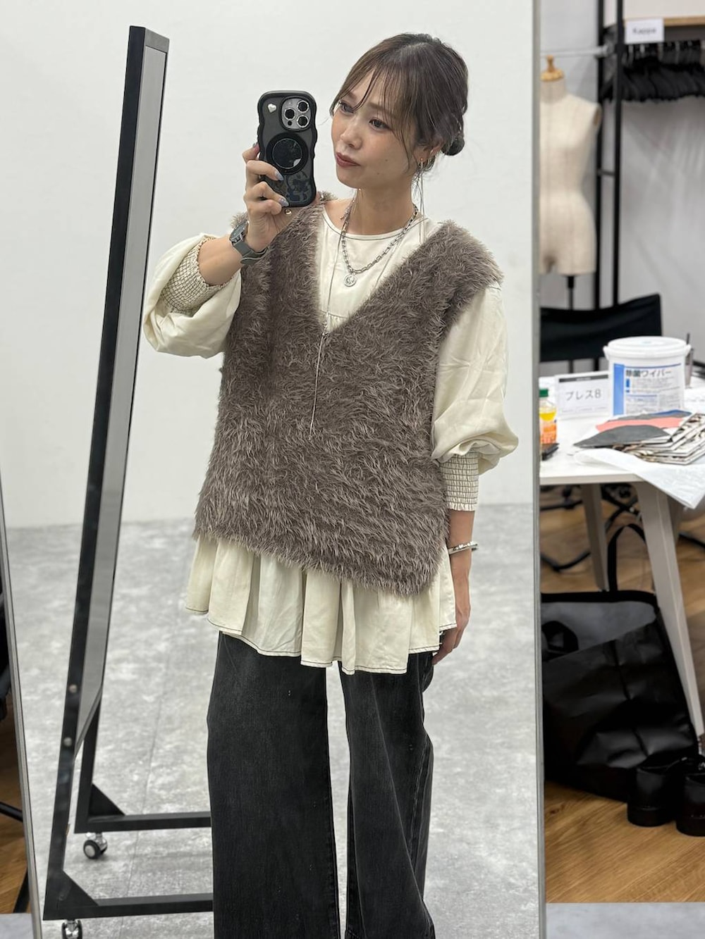 グリーン系のボストンバッグ、ブルー系のシャツ/ブラウス、グレー系のベストを着用したレディースの秋コーディネートの5枚目の写真