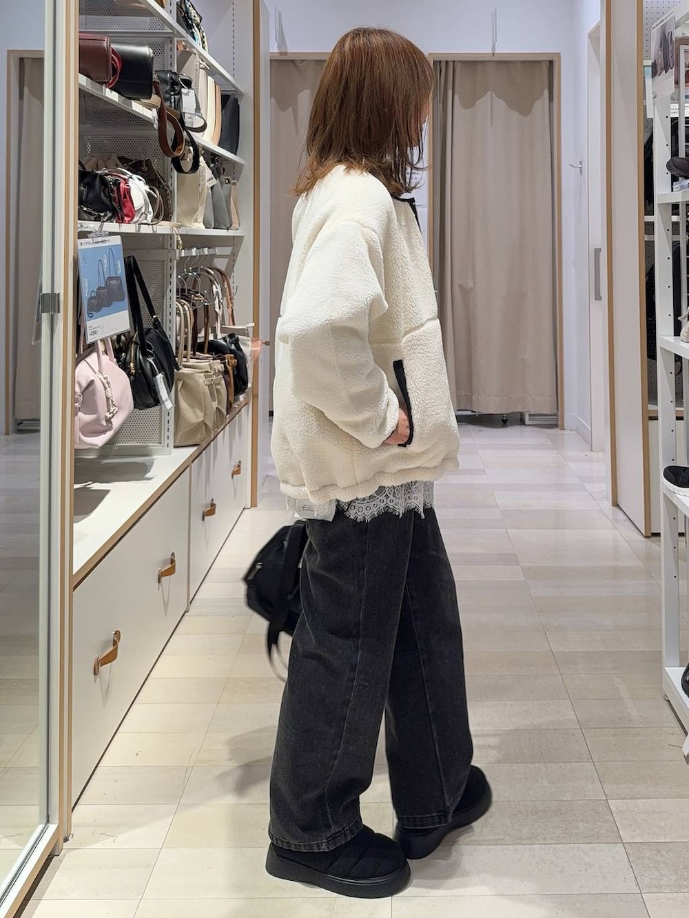 ホワイト系のTシャツ/カットソー、ブラック系のショルダーバッグ、ブラック系のデニムパンツを着用したレディースの秋コーディネートの5枚目の写真
