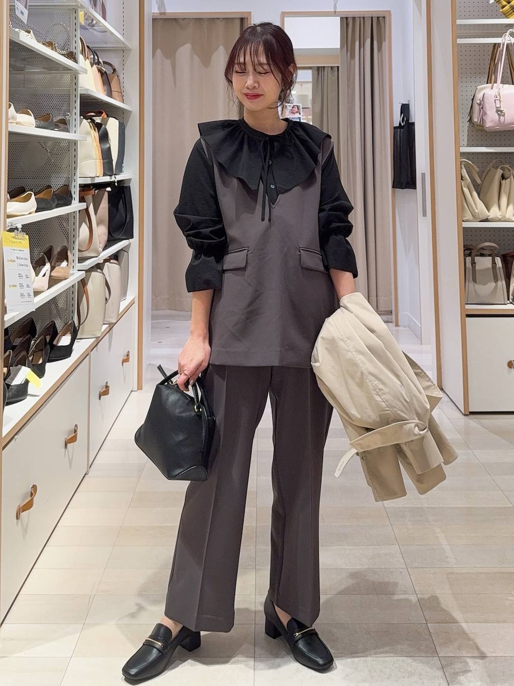 ホワイト系のショルダーバッグ、ブラック系のパンプス、グレー系のセットアップを着用したレディースの冬コーディネートの2枚目の写真