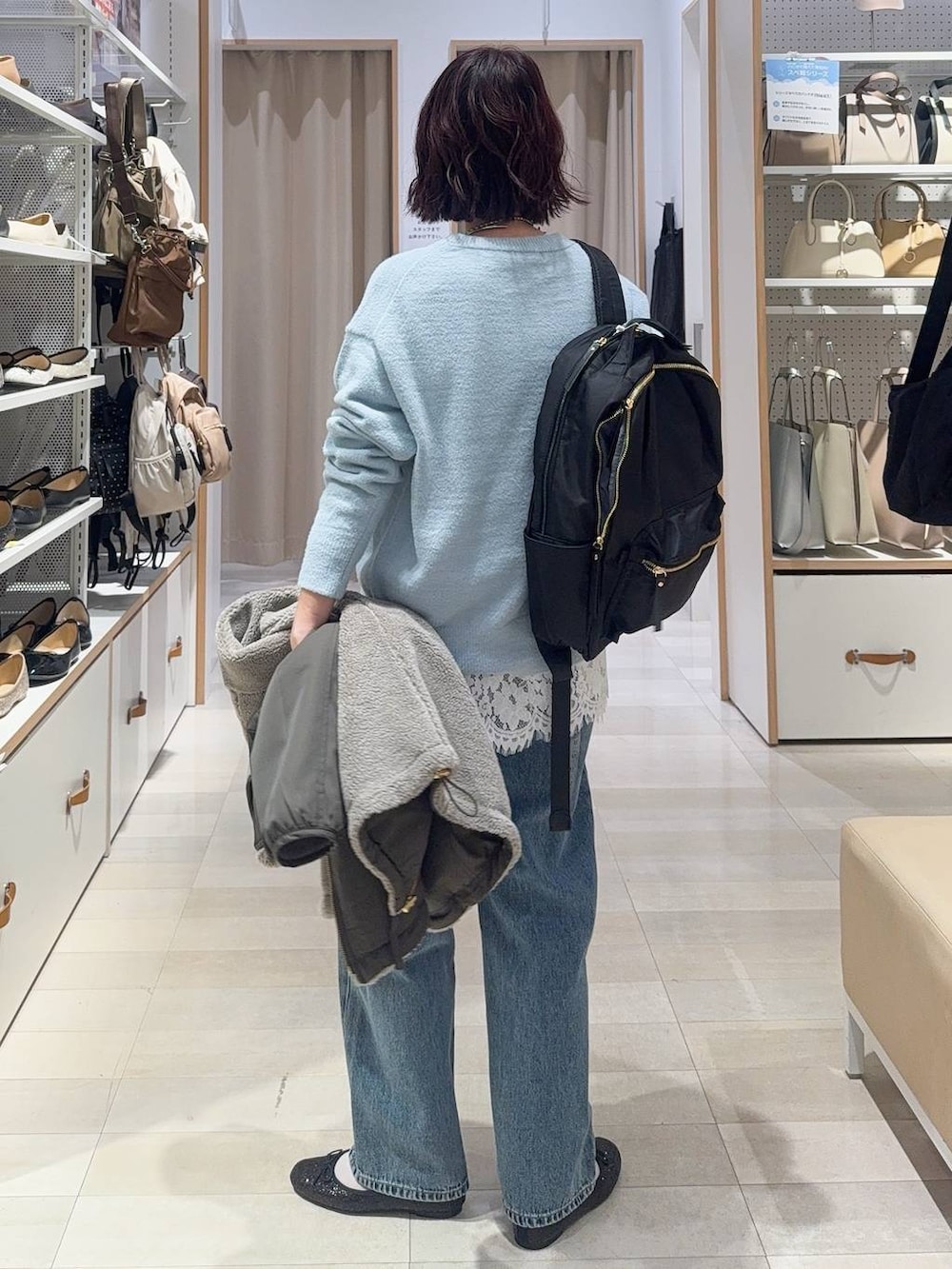 ブラック系のバレエシューズ、グレー系のブルゾン、ブルー系のデニムパンツを着用したレディースの秋コーディネートの9枚目の写真