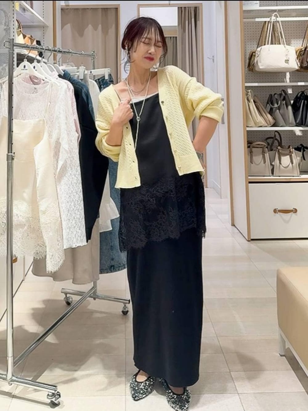 ホワイト系のシャツ/ブラウス、ホワイト系のステンカラーコート、イエロー系のカーディガン/ボレロを着用したレディースの冬コーディネートの5枚目の写真