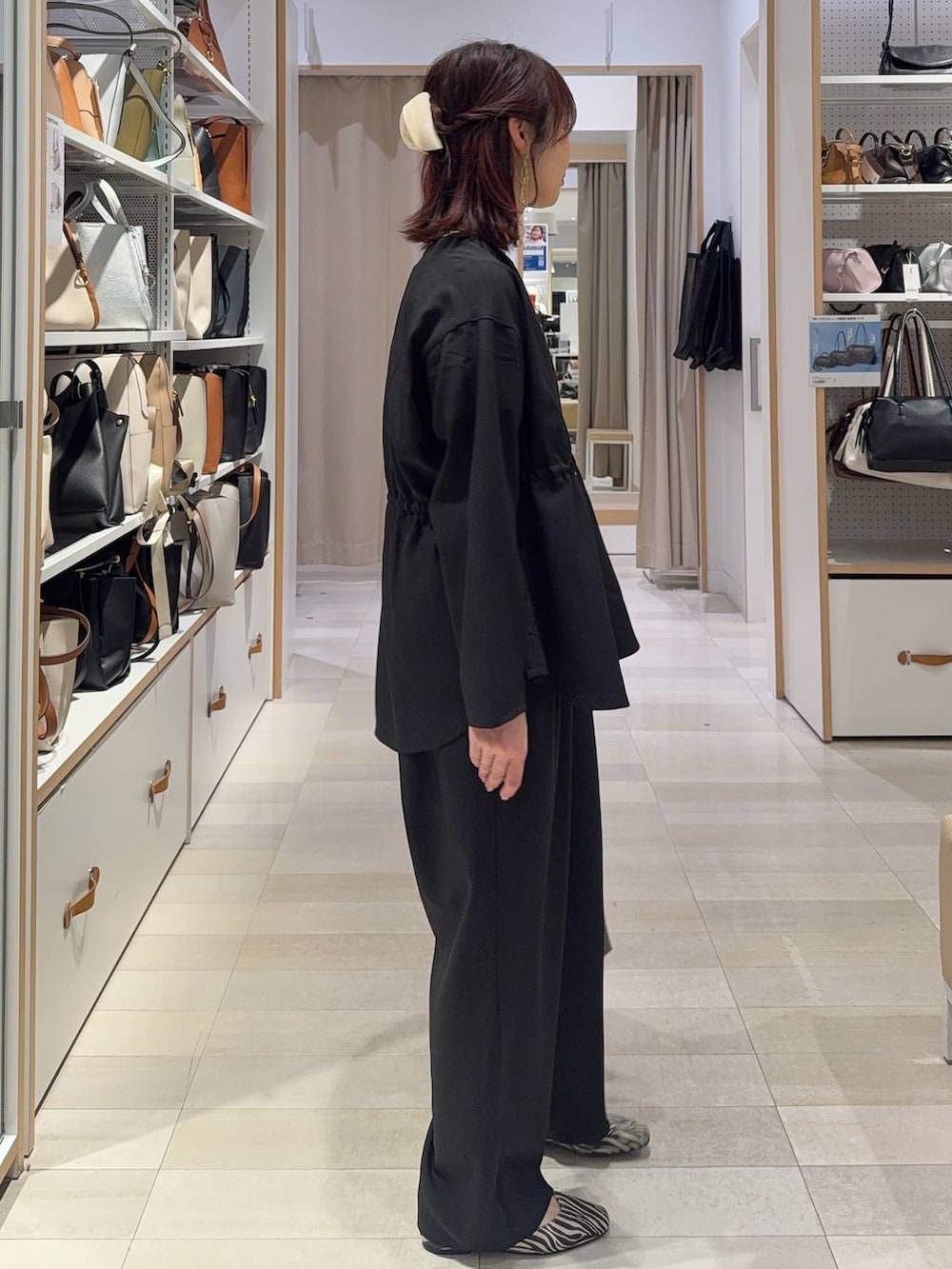 その他のパンプス、グレー系のハンドバッグ、ブラック系のその他パンツを着用したレディースの春コーディネートの3枚目の写真