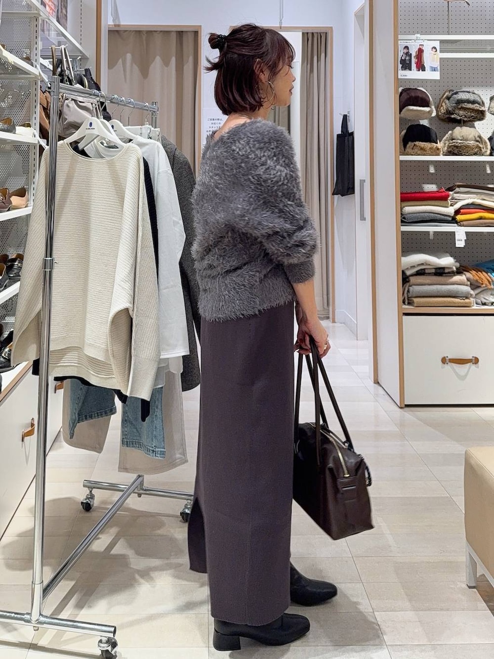 ブラック系のバックパック/リュック、グレー系のワンピース、ホワイト系のTシャツ/カットソーを着用したレディースの冬コーディネートの7枚目の写真