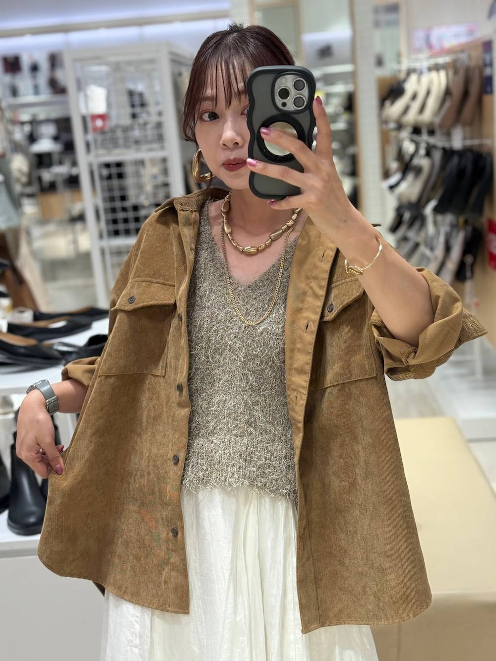 イエロー系のシャツ/ブラウス、ベージュ系のスカート、ブラック系のボストンバッグを着用したレディースの秋コーディネートの2枚目の写真