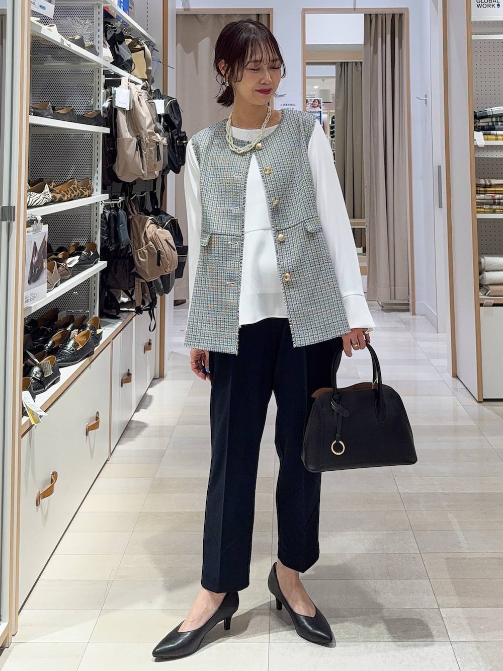 ブラック系のショルダーバッグ、ブラック系のパンプス、ブルー系のセットアップを着用したレディースの冬コーディネートの4枚目の写真